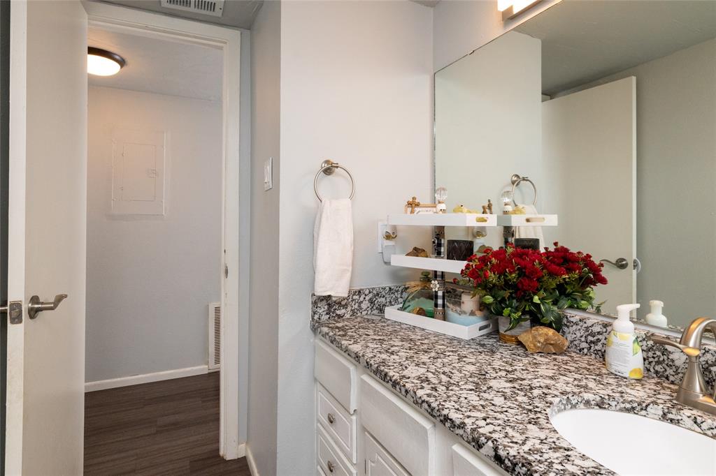 108 Harbor Drive, Unit 204 Runaway Bay, TX 76426 - Photo 19 of 22 a bathroom with a granite countertop sink a mirror and a shower
