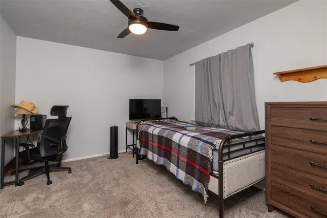 a view of a bedroom with workspace and windows