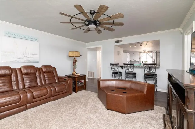 a living room with furniture a chandelier and a dining table