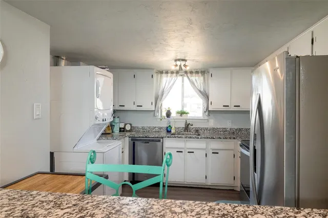 a kitchen with kitchen island granite countertop a sink stove and refrigerator