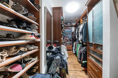 a view of walk in closet with clothes and shoes