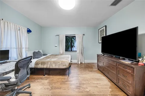 a bedroom with a bed and a flat tv screen on wall