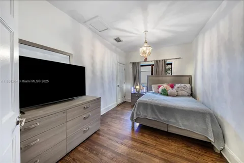 a bedroom with bed and flat screen tv