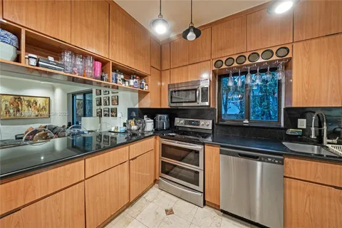 a kitchen with stainless steel appliances granite countertop a sink a stove and cabinets