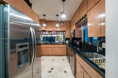 a kitchen with granite countertop a refrigerator and a sink