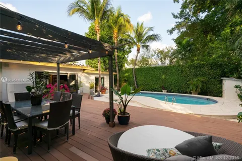 a view of a patio with table and chairs potted plants and palm tree