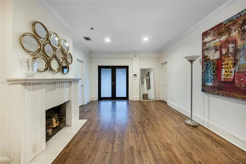 a view of a room with wooden floor fireplace and window