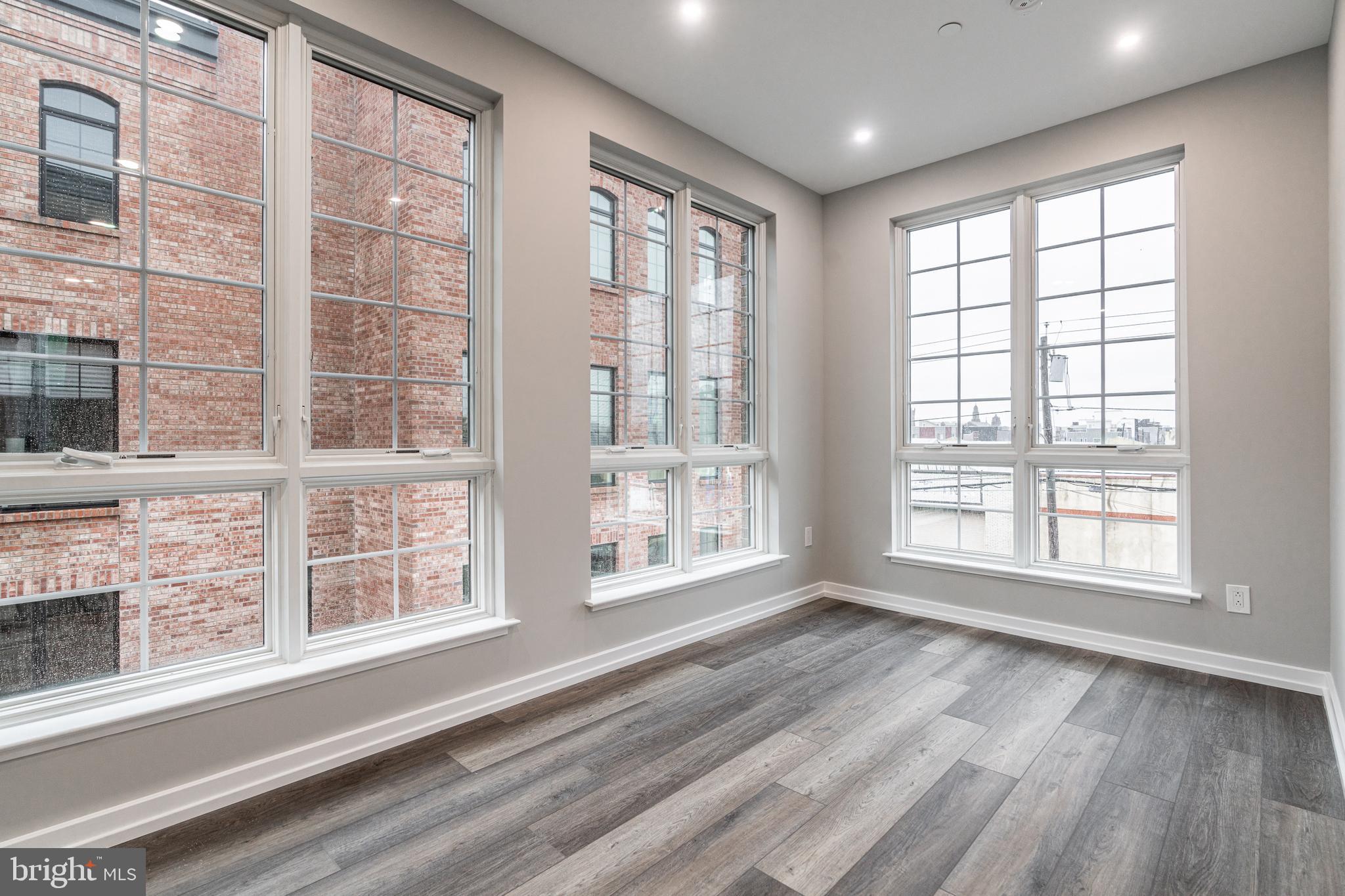 2412 Innovator Way, Unit 3 Philadelphia, PA 19146 - Photo 3 of 25 a view of an empty room with a window and wooden floor