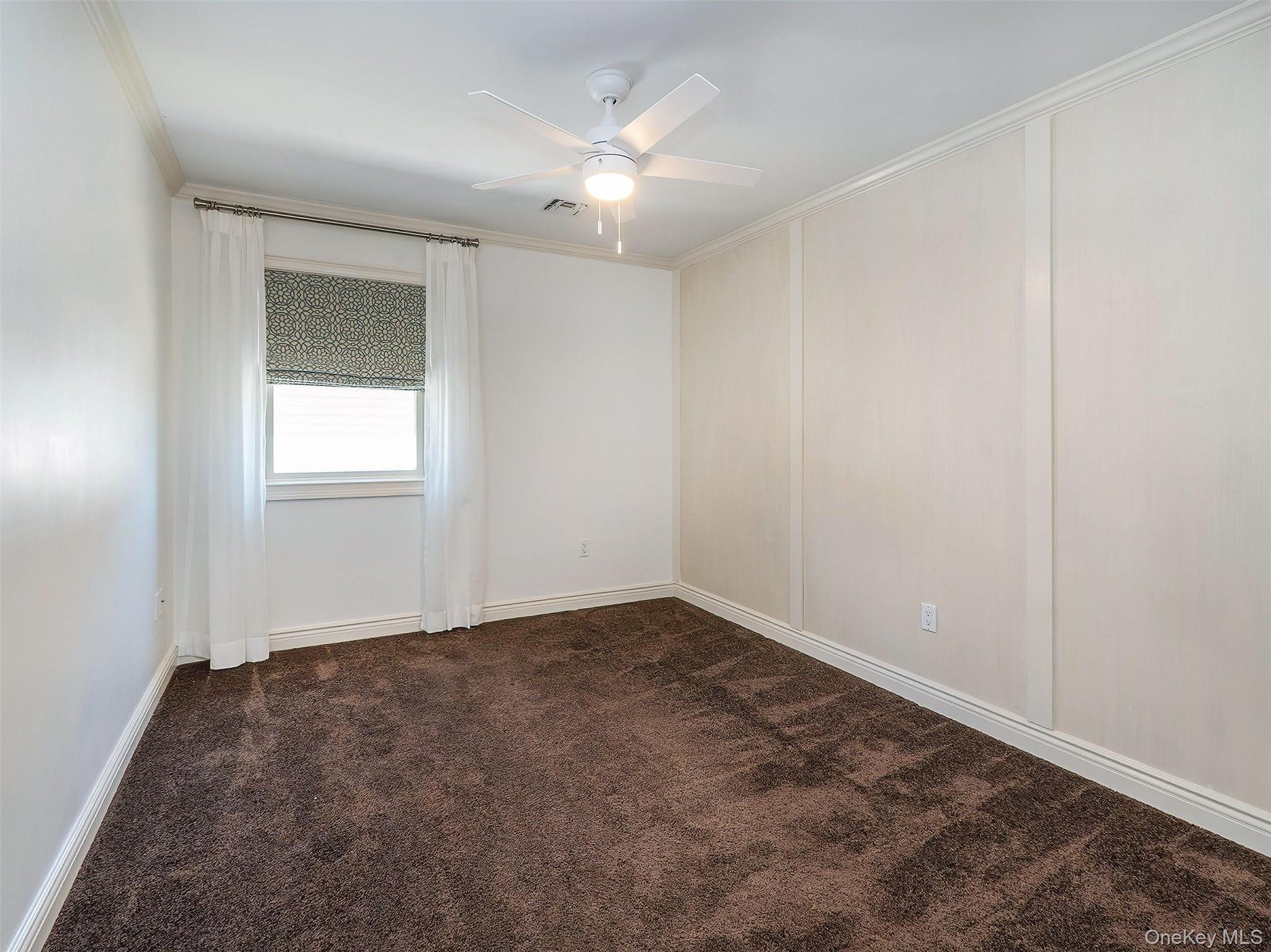 21 Marwood Road North Port Washington, NY 11050 - Photo 23 of 35 an empty room with chandelier fan and windows
