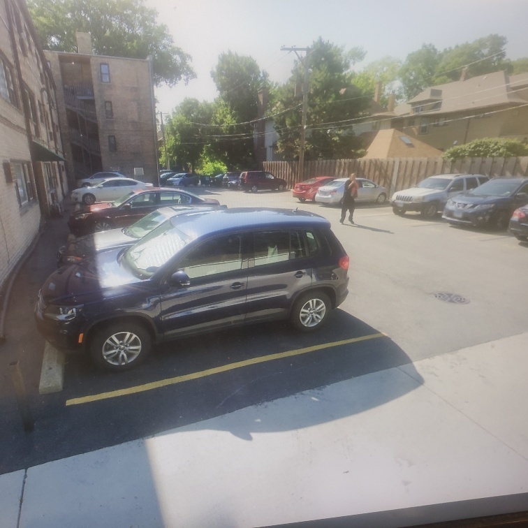 a view of a street with a car parked on the road