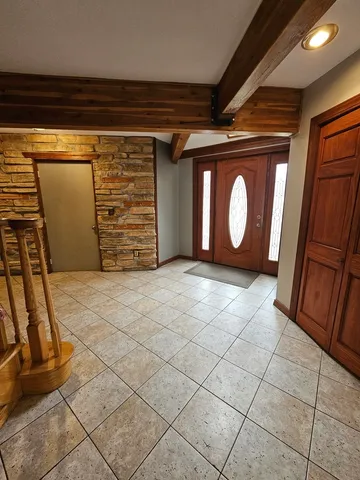 a view of an empty room with wooden floor and windows