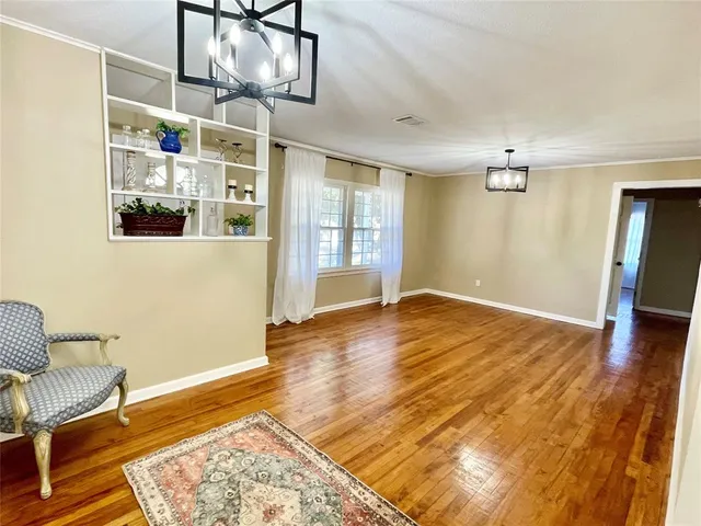 a view of a livingroom with wooden floor and furniture