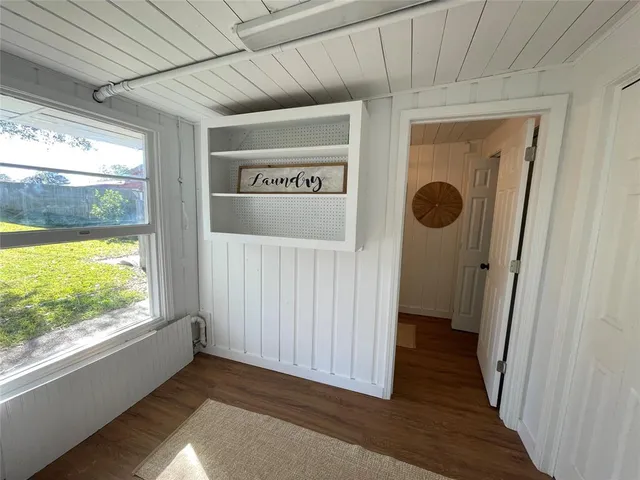a view of a hallway with wooden floor and a window