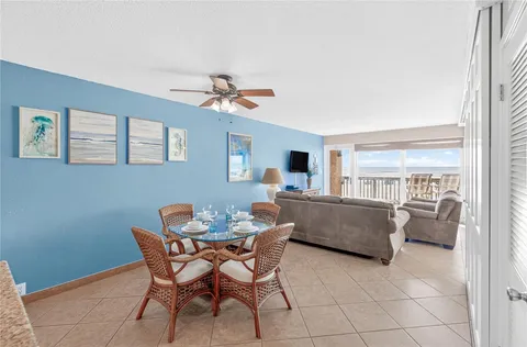 a view of a dining room with furniture and a chandelier fan
