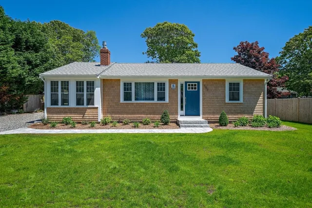 a front view of house with yard and green space