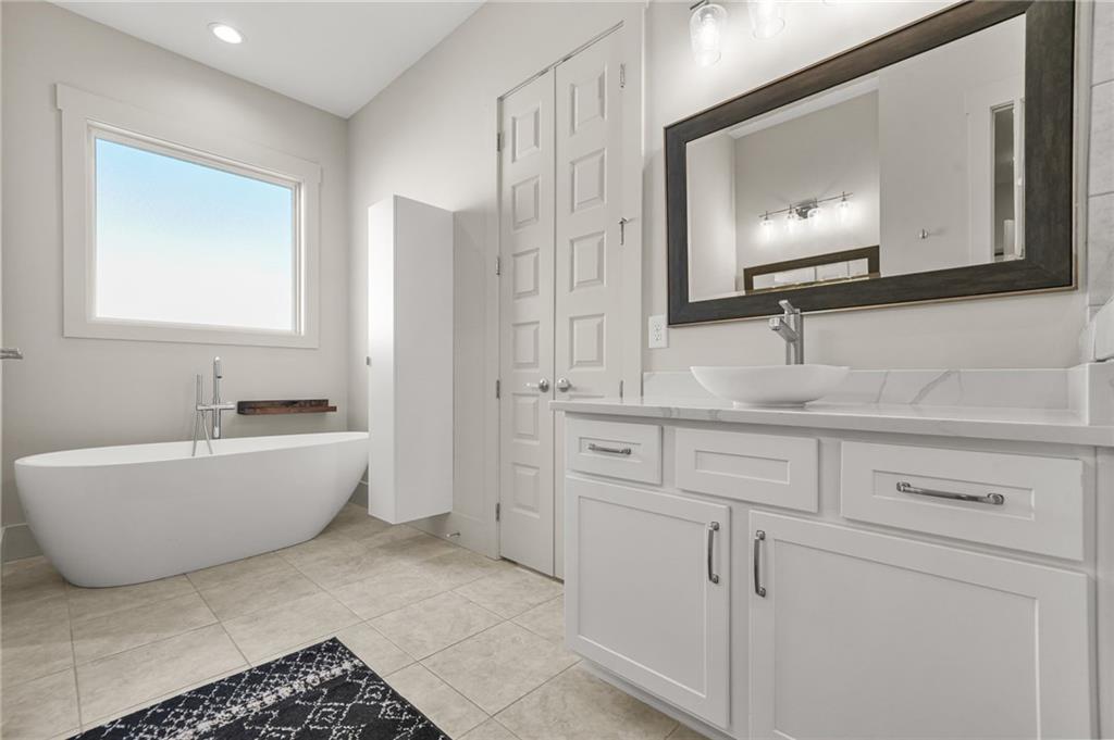 265 Holland Road Powder Springs, GA 30127 - Photo 12 of 27 a bathroom with a bathtub a mirror and sink