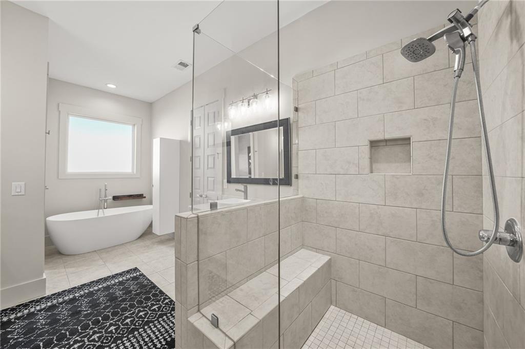 265 Holland Road Powder Springs, GA 30127 - Photo 5 of 27 a bathroom with a tub a window and glass door shower