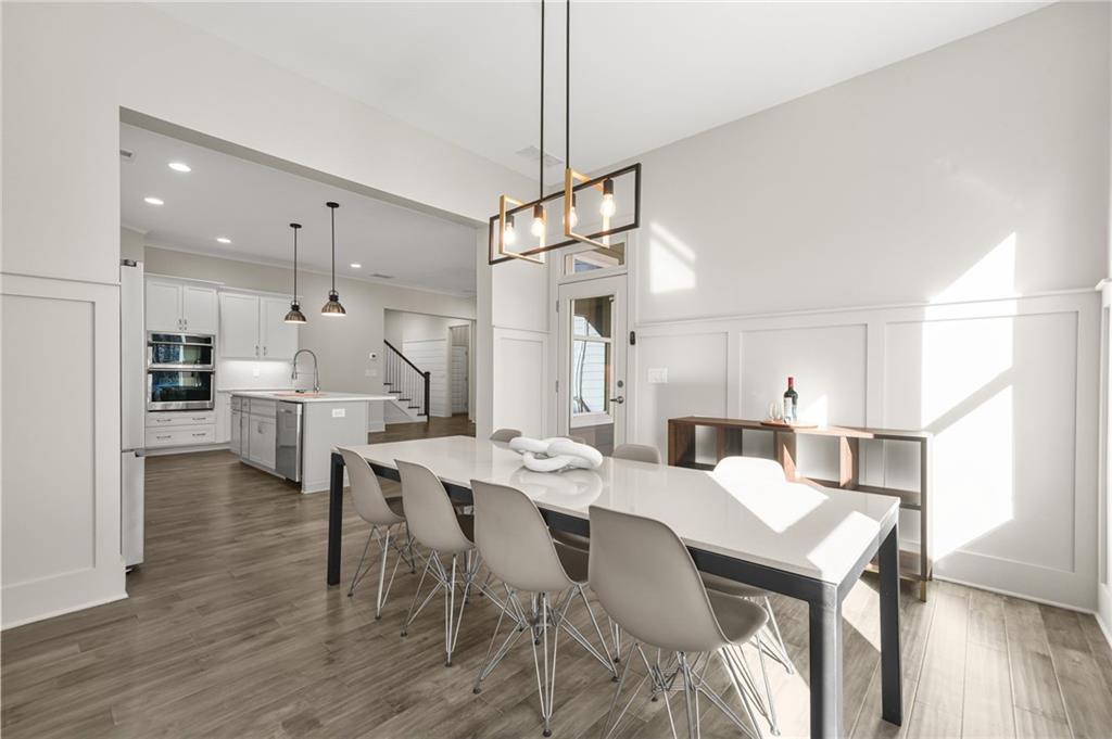 265 Holland Road Powder Springs, GA 30127 - Photo 9 of 27 a open kitchen with stainless steel appliances kitchen island granite countertop a dining table chairs and white cabinets