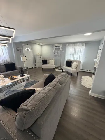 a living room with couches and a large mirror with wooden floor