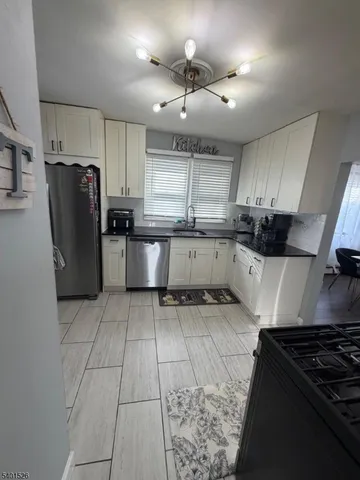 a kitchen with a refrigerator a sink and wooden cabinets