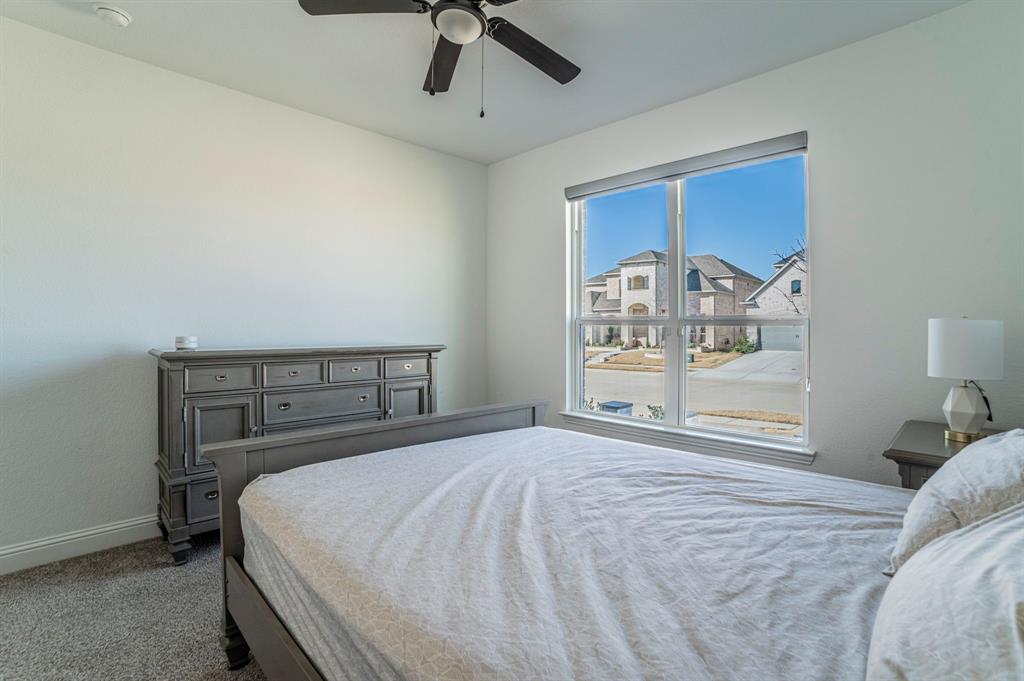 2519 Bedford Road Northlake, TX 76226 - Photo 27 of 33 a bedroom with a large bed and a chandelier