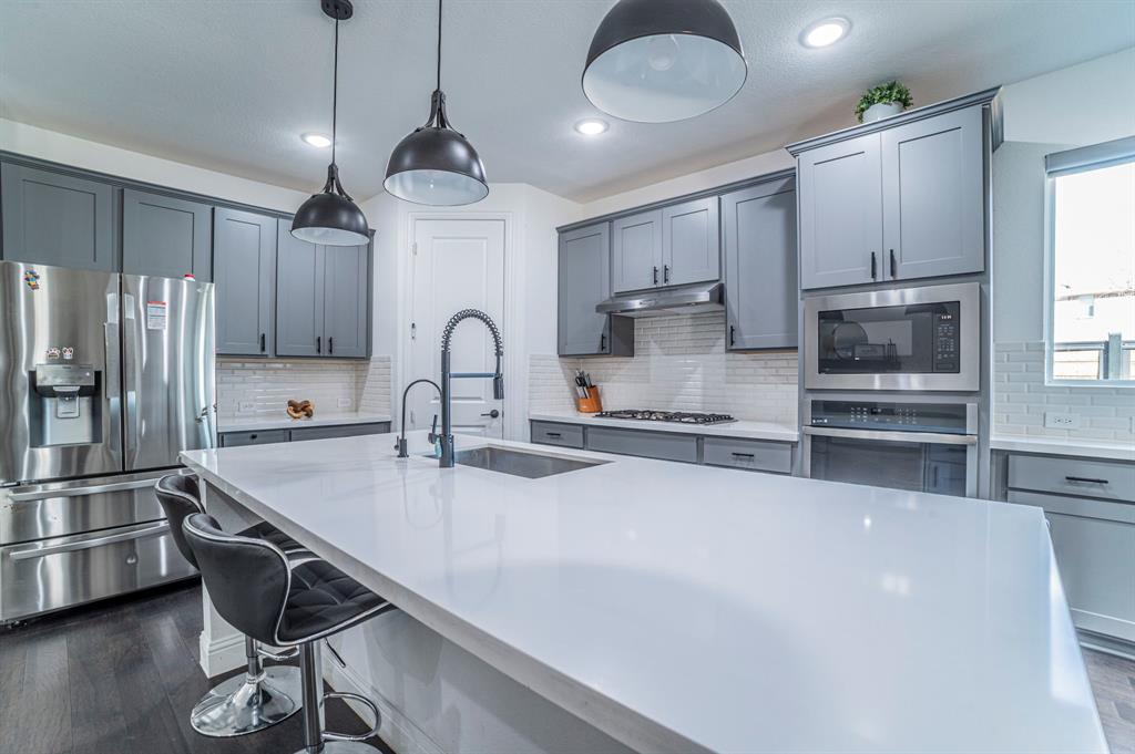 2519 Bedford Road Northlake, TX 76226 - Photo 7 of 33 a kitchen with kitchen island a sink stainless steel appliances and cabinets