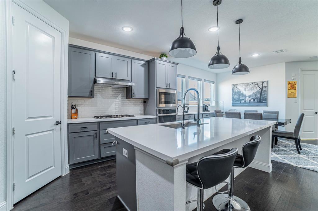 2519 Bedford Road Northlake, TX 76226 - Photo 8 of 33 a kitchen with stainless steel appliances granite countertop a sink a stove a refrigerator cabinets and chairs