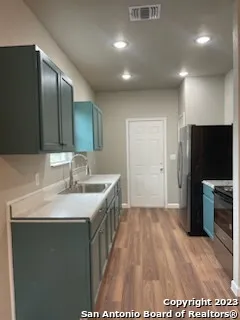 a view of an empty room with a kitchen and a window