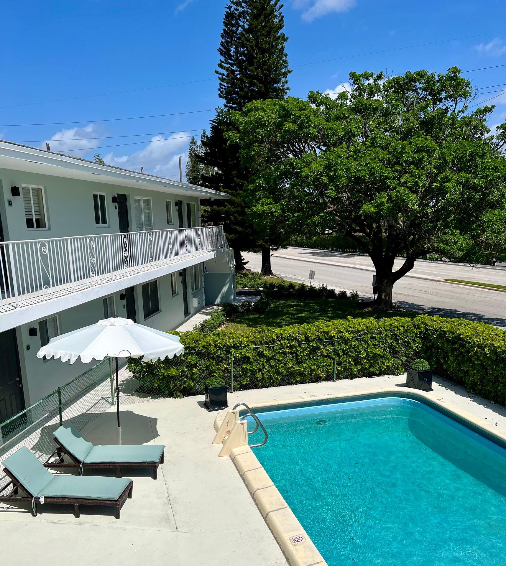480 West Camino Real, Unit 24 Boca Raton, FL 33432 - Photo 2 of 13 a front view of a house with a yard balcony and outdoor seating