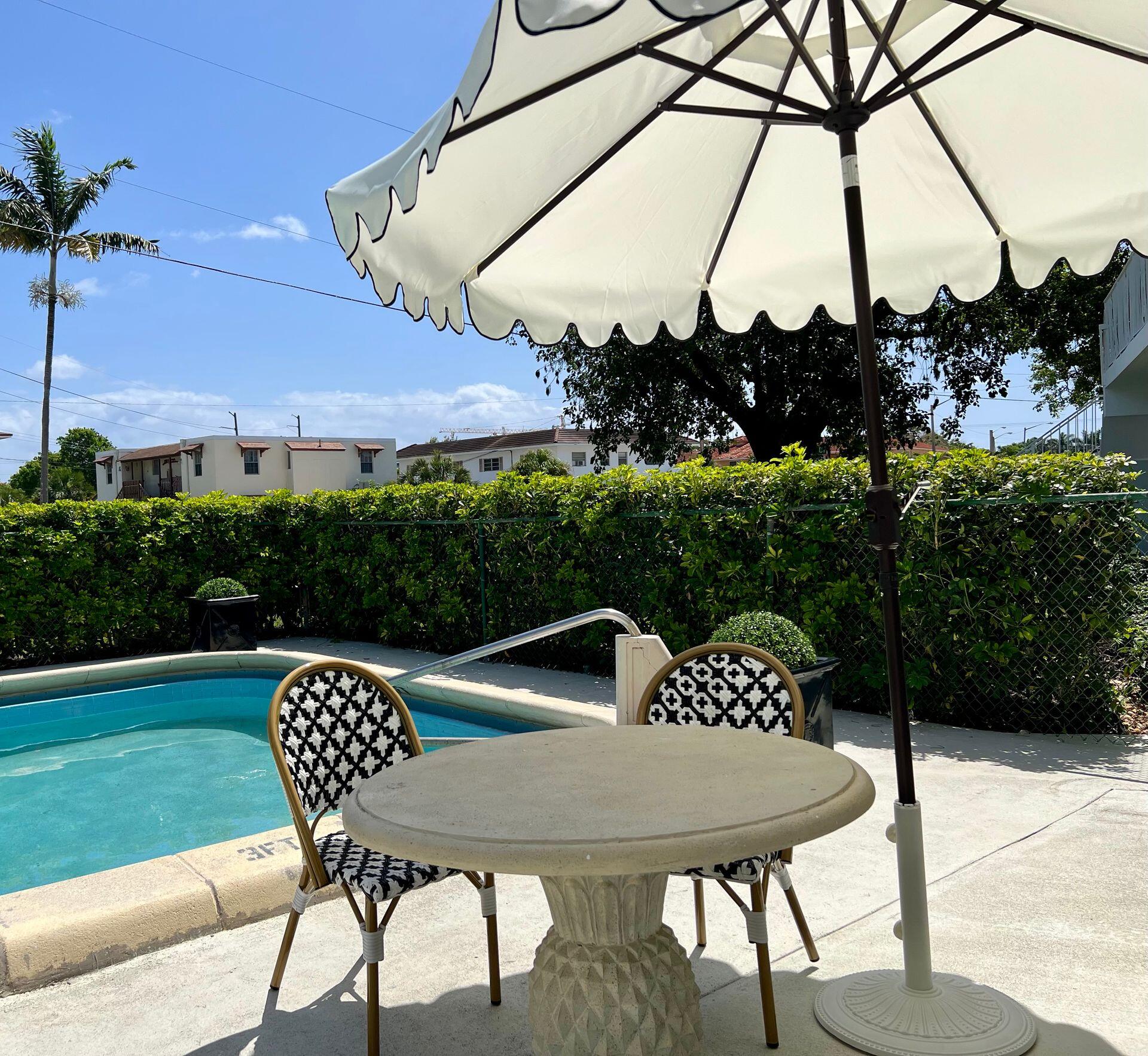 480 West Camino Real, Unit 24 Boca Raton, FL 33432 - Photo 4 of 13 a table and chairs with the table in the back yard