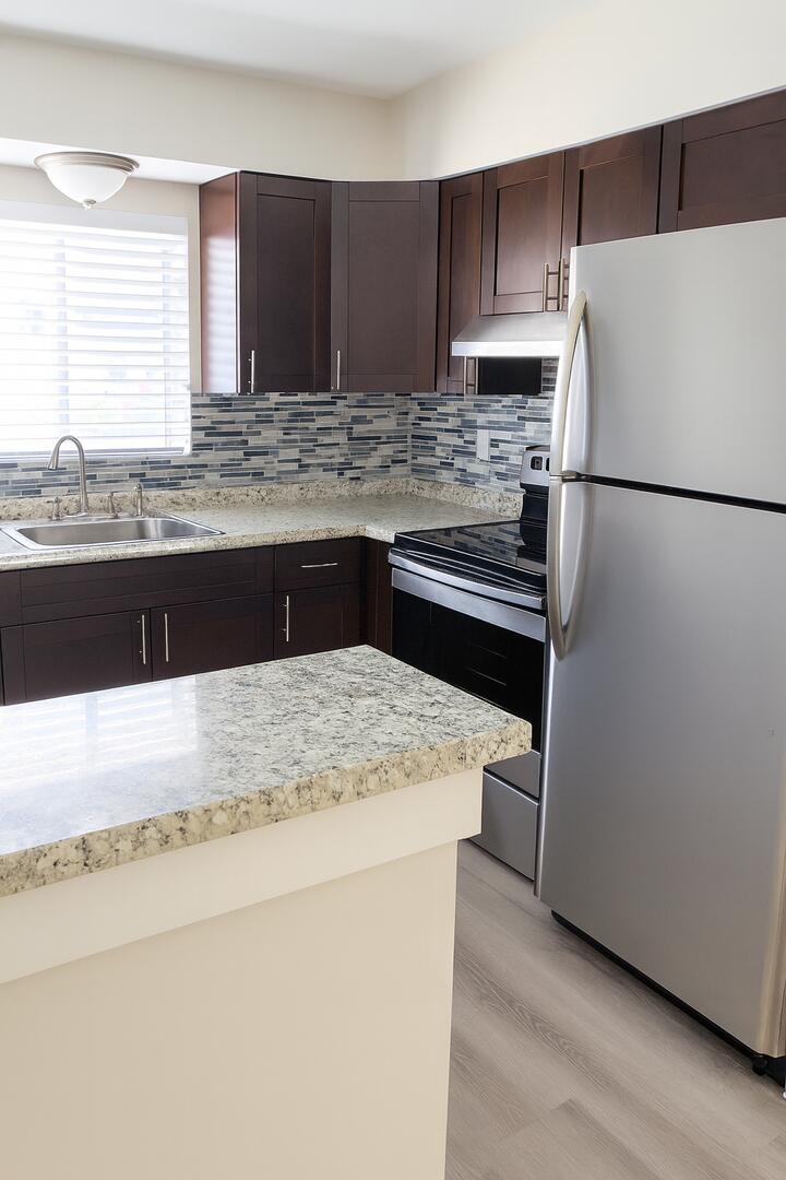 480 West Camino Real, Unit 24 Boca Raton, FL 33432 - Photo 5 of 13 a kitchen with stainless steel appliances granite countertop a refrigerator a sink dishwasher a stove top oven a refrigerator and dishwasher