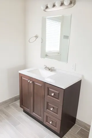 a bathroom with a sink vanity and a mirror