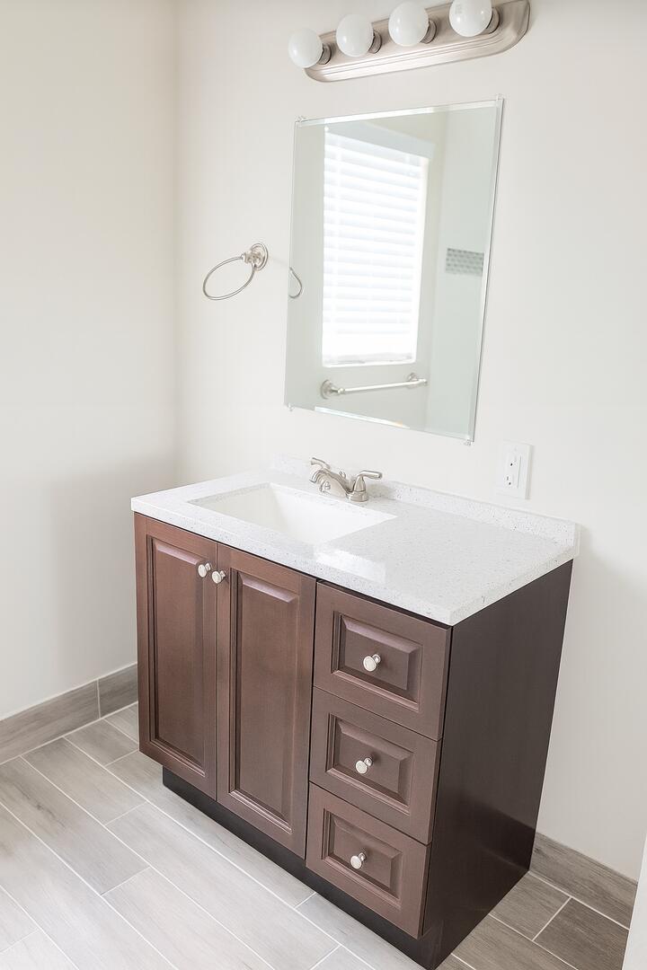 480 West Camino Real, Unit 24 Boca Raton, FL 33432 - Photo 8 of 13 a bathroom with a sink vanity and a mirror