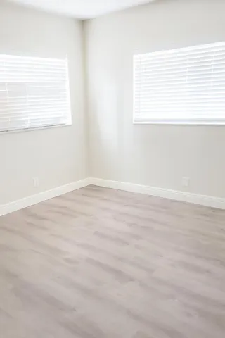 an empty room with wooden floor and a window
