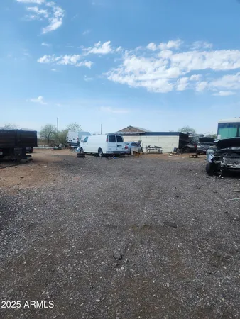 a view of dirt road with a building