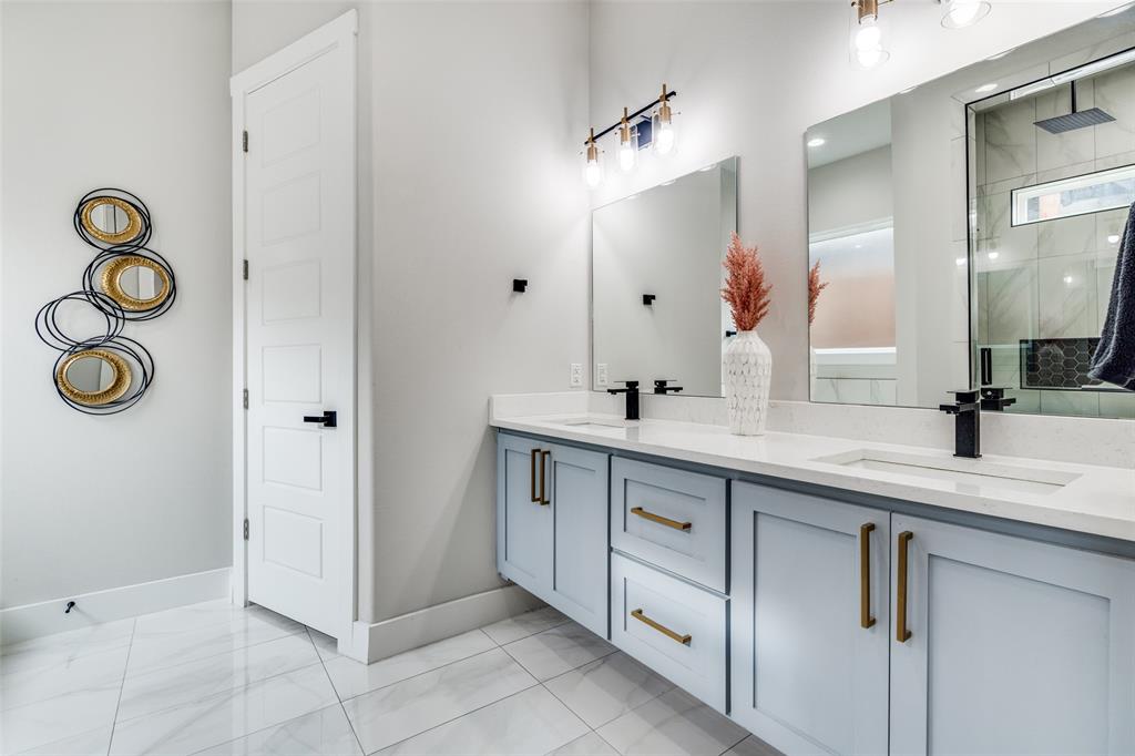 518 Crete Street Dallas, TX 75203 - Photo 12 of 27 EnSuite full bathroom featuring double vanity, a stall shower, and light marble finish flooring