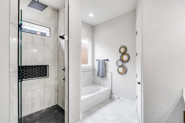 a bathroom with a tub shower and mirror