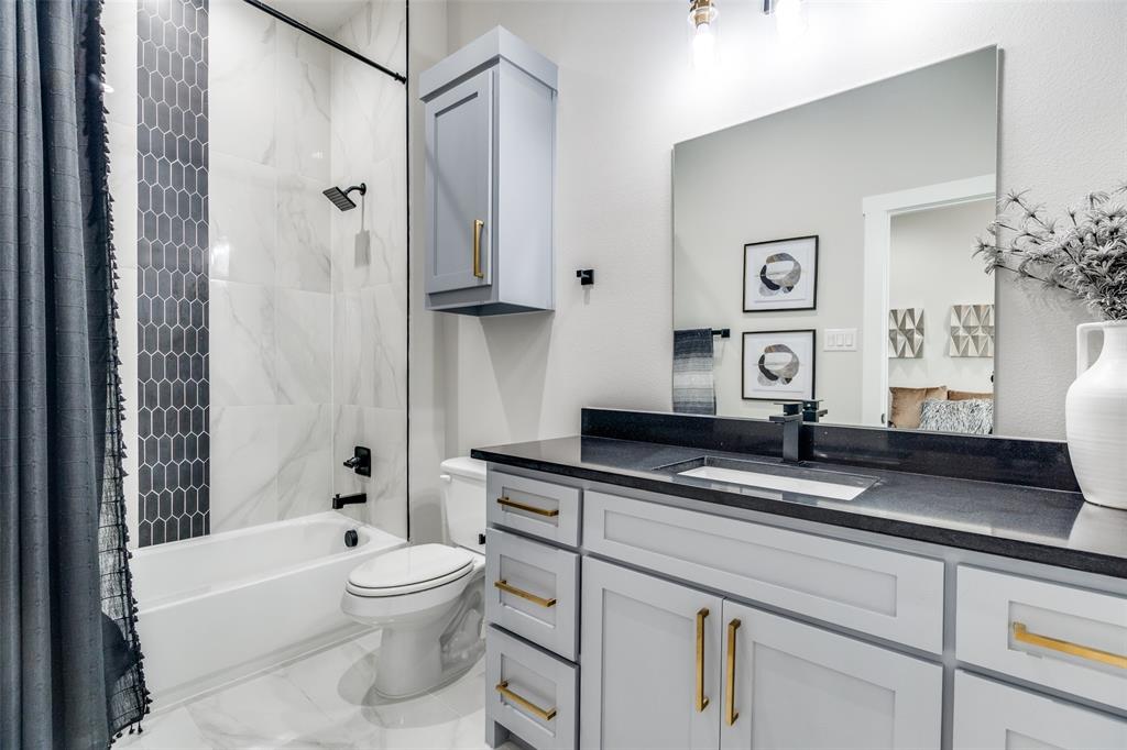518 Crete Street Dallas, TX 75203 - Photo 19 of 27 Bathroom featuring shower / bathtub combination with curtain, vanity, and marble look tile flooring