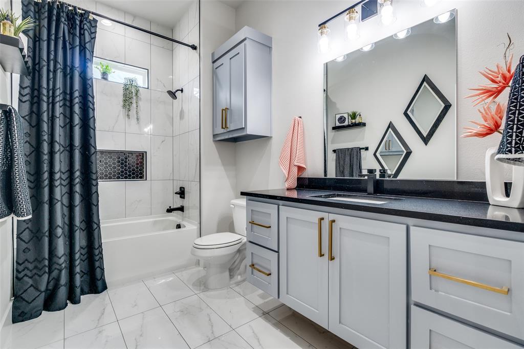 518 Crete Street Dallas, TX 75203 - Photo 21 of 27 Bathroom featuring shower / bath combination with curtain, vanity, and light marble finish flooring