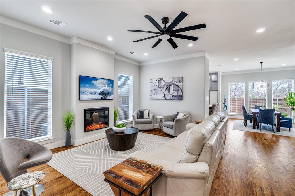 518 Crete Street Dallas, TX 75203 - Photo 5 of 27 Living area featuring crown molding, wood finished floors, a glass covered fireplace, a ceiling fan, and recessed lighting