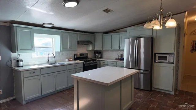 a kitchen with sink a refrigerator and cabinets