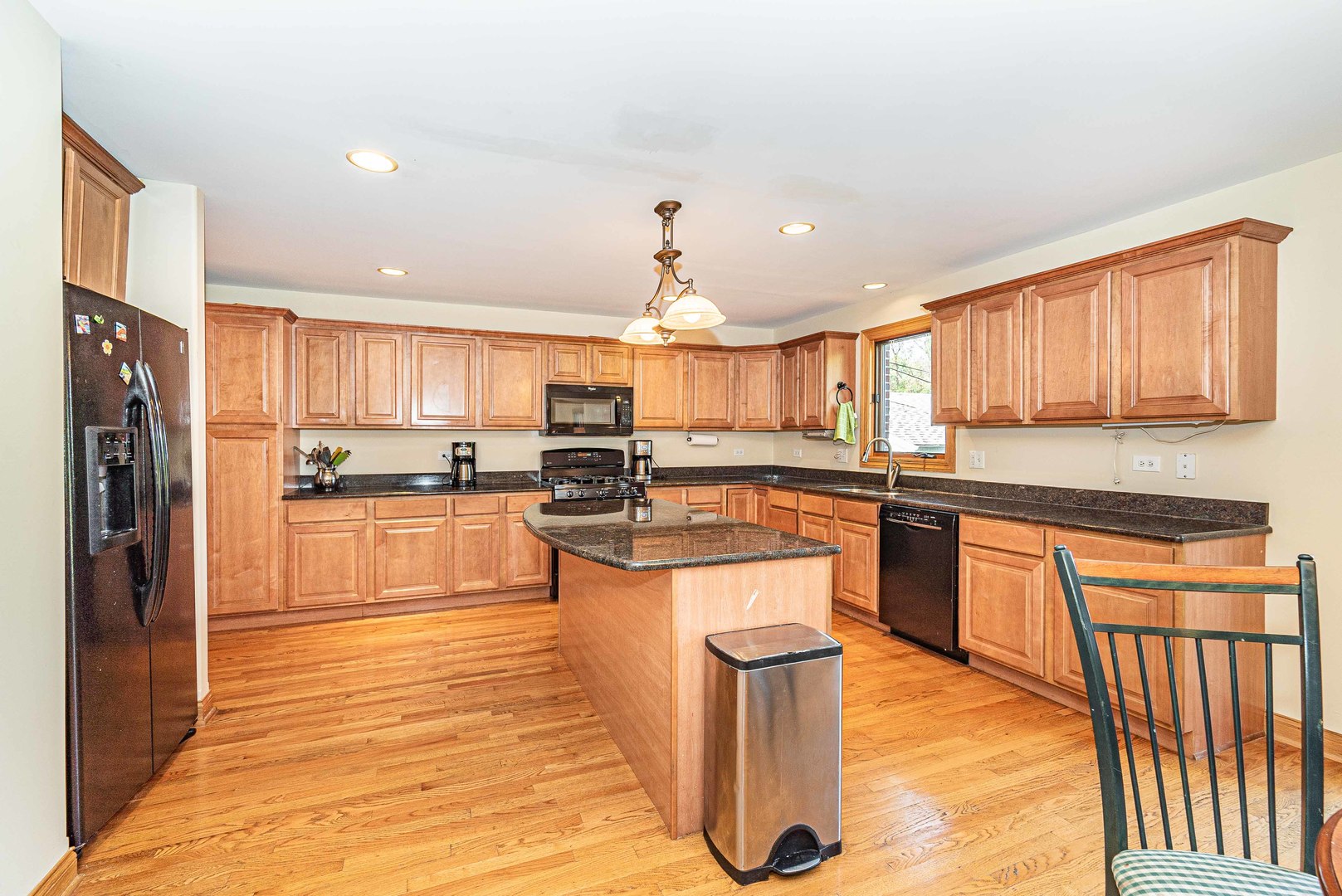 10551 Princess Avenue Chicago Ridge, IL 60415 - Photo 8 of 26 a kitchen with stainless steel appliances granite countertop a stove top oven a refrigerator a sink and dishwasher with wooden floor