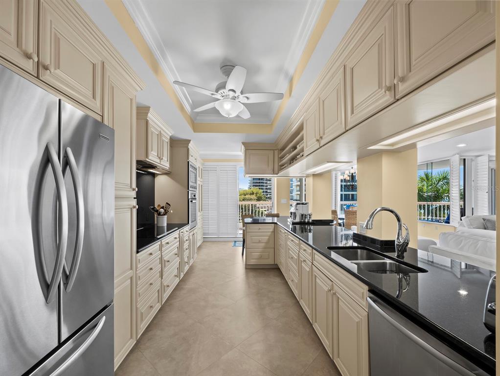 455 Longboat Club Road, Unit 402 Longboat Key, FL 34228 - Photo 12 of 50 a kitchen with granite countertop a refrigerator and a sink