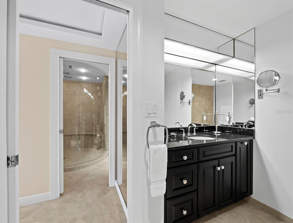 455 Longboat Club Road, Unit 402 Longboat Key, FL 34228 - Photo 18 of 50 a bathroom with a granite countertop sink a mirror and a shower
