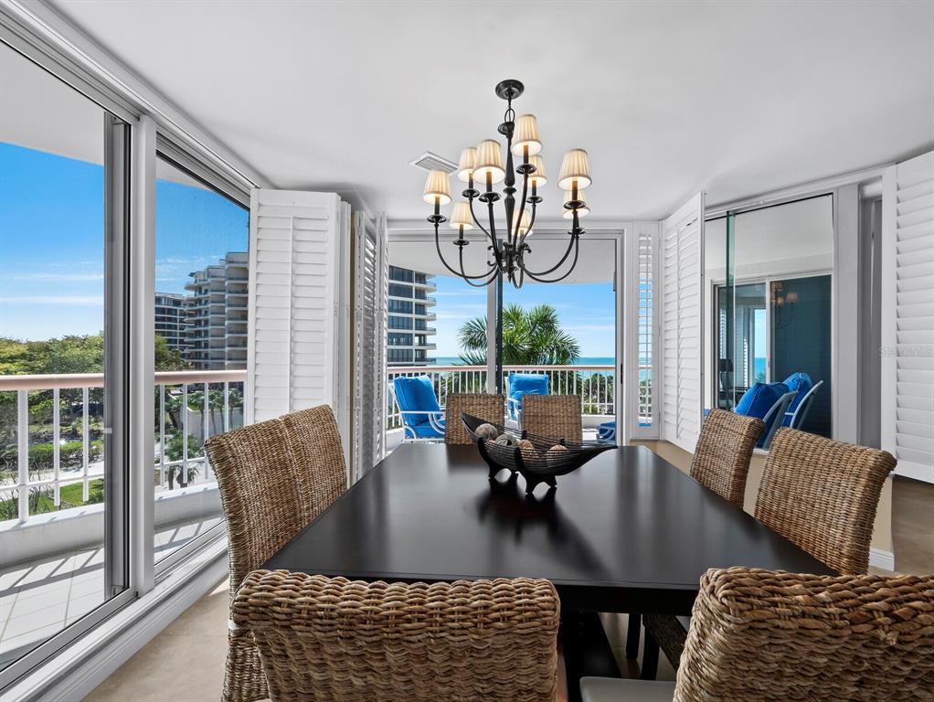 455 Longboat Club Road, Unit 402 Longboat Key, FL 34228 - Photo 8 of 50 a view of a dining room with furniture wooden floor and chandelier