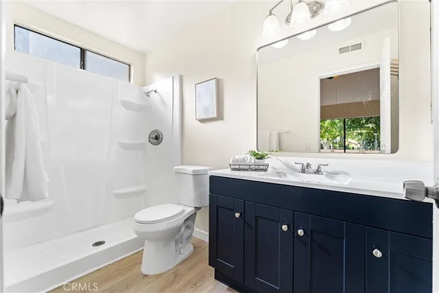 a bathroom with a sink vanity toilet and shower
