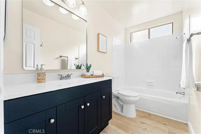 a bathroom with a double vanity sink toilet mirror and bathtub