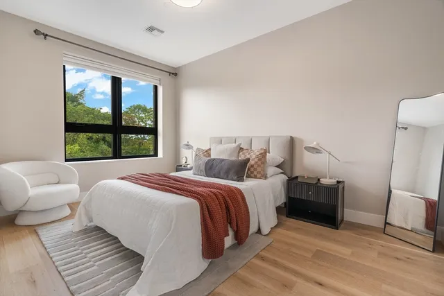 a bedroom with bed and a large window