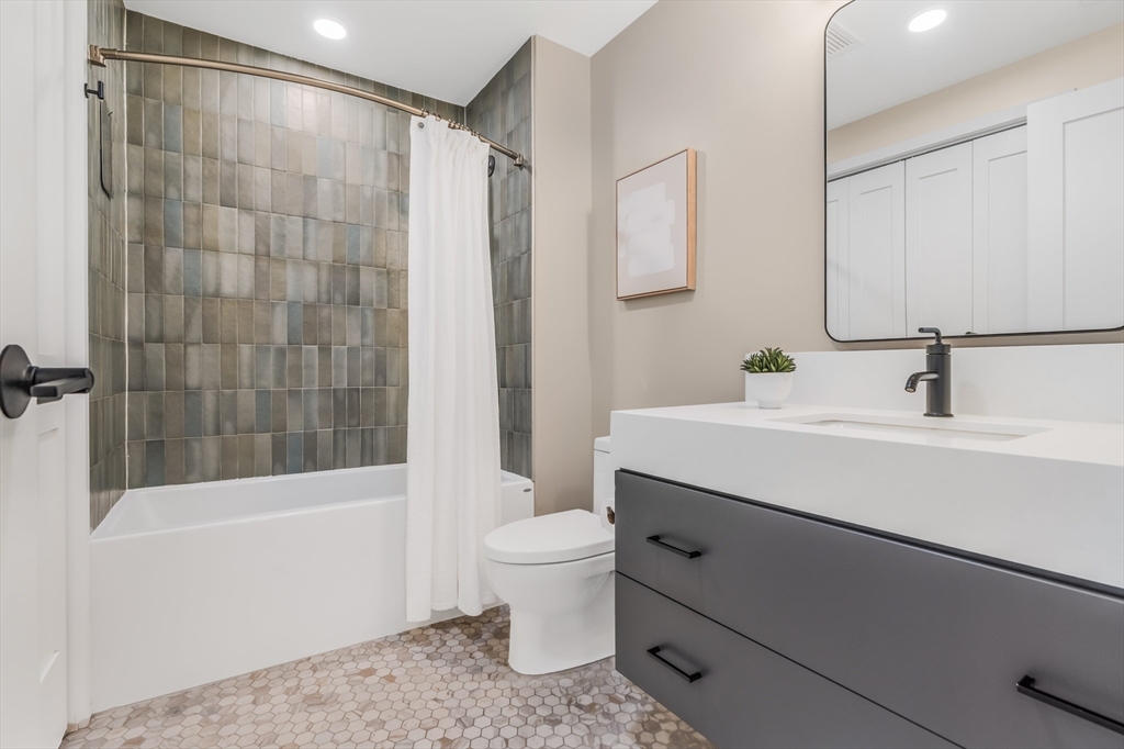 70 Leo M Birmingham Parkway, Unit U307 Boston, MA 02135 - Photo 13 of 35 a bathroom with a sink a toilet and shower
