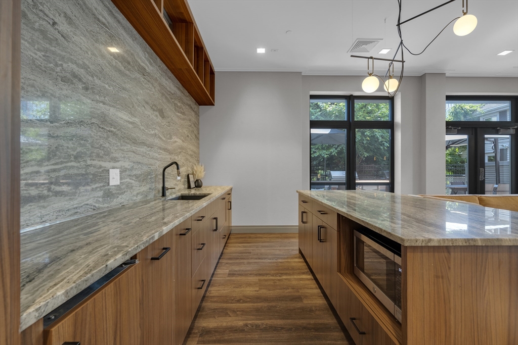 70 Leo M Birmingham Parkway, Unit U307 Boston, MA 02135 - Photo 26 of 35 a kitchen with stainless steel appliances granite countertop counter space a sink and stove